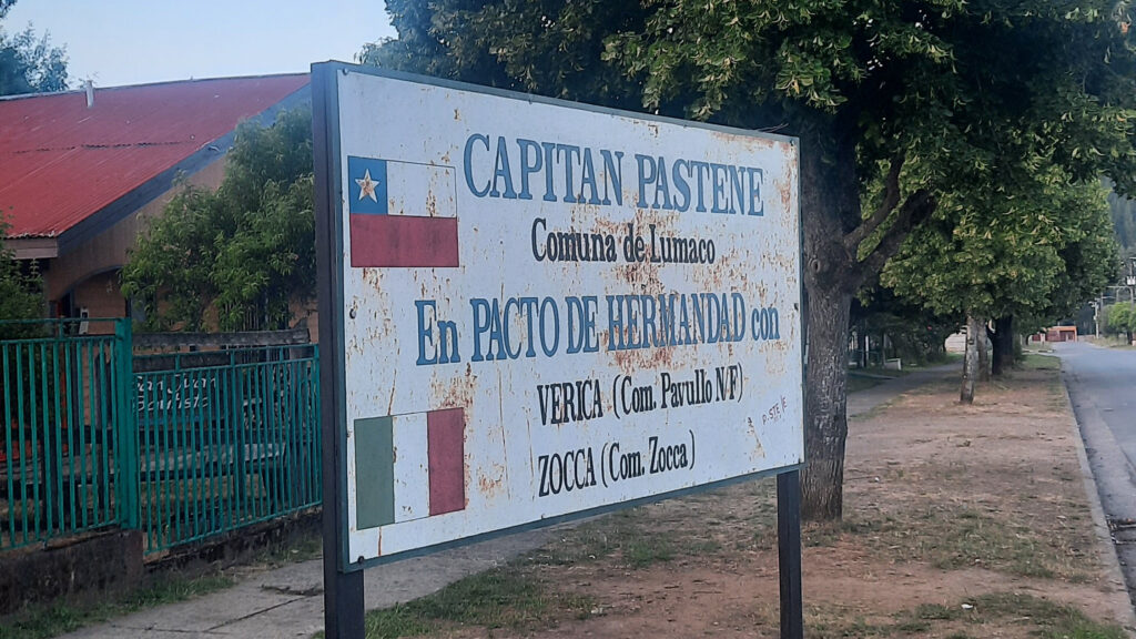Cartel dónde se lee: "Capitán Pastene, Comuna de Lumaco, en pacto de hermandad con Verica y Zocca"